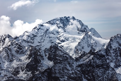 冰雪覆盖下的山在白天多云的天空
